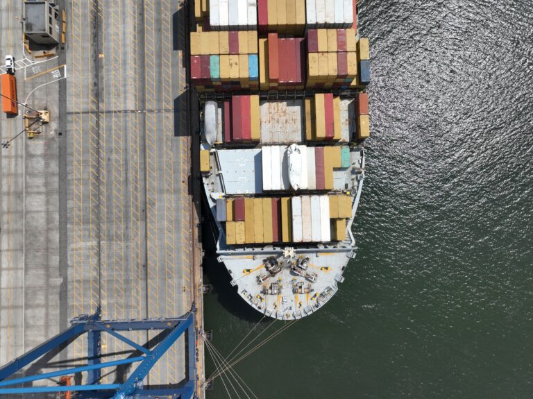 Aerial top-down view of a container ship docked at a port terminal.
