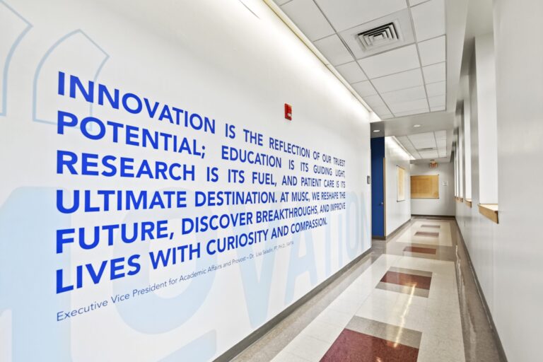 Hallway with a large blue wall quote about innovation and research at MUSC.