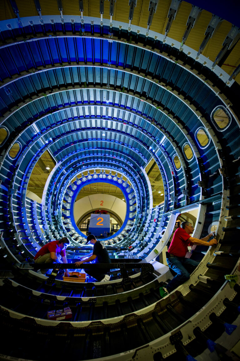 Three people work on the interior of an aircraft at the Boeing facility in Charleston, SC.