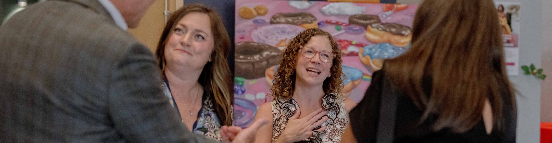 A group of coworkers smile and talk with each other.