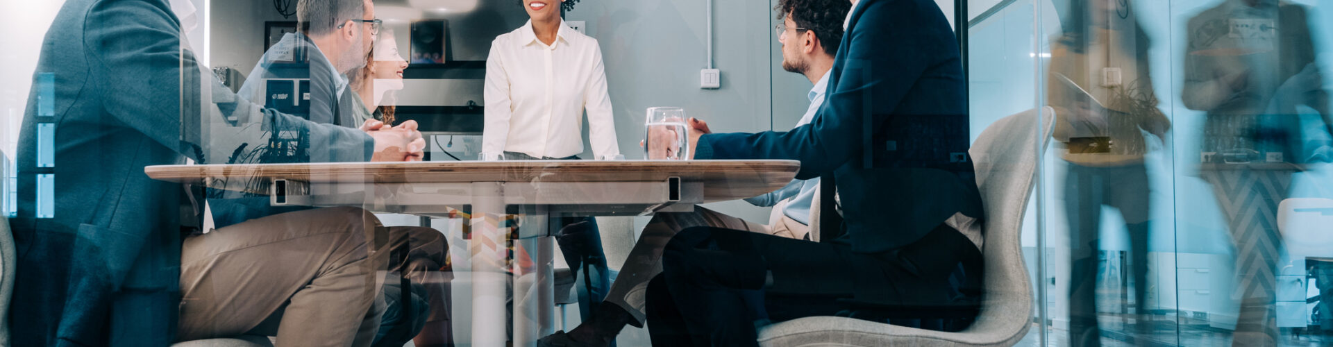 A team of business people sit around a conference table.