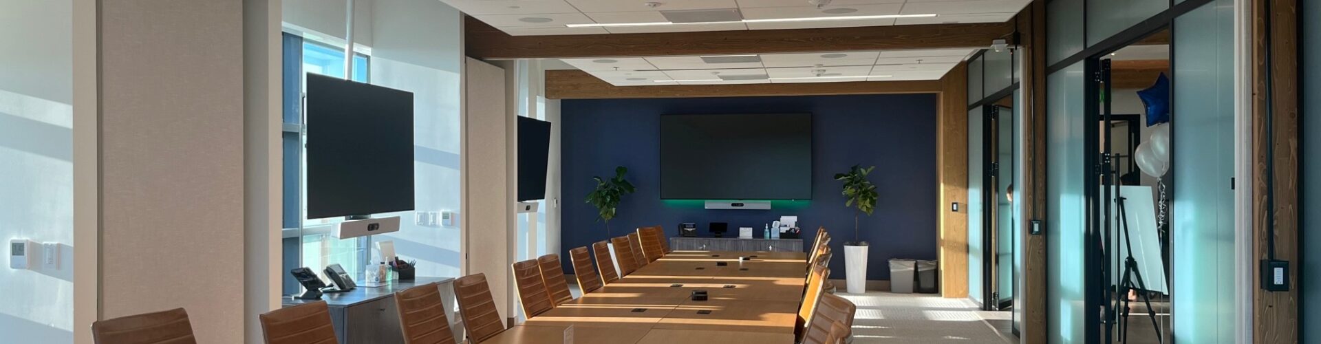 The interior of a modern corporate boardroom during the day.