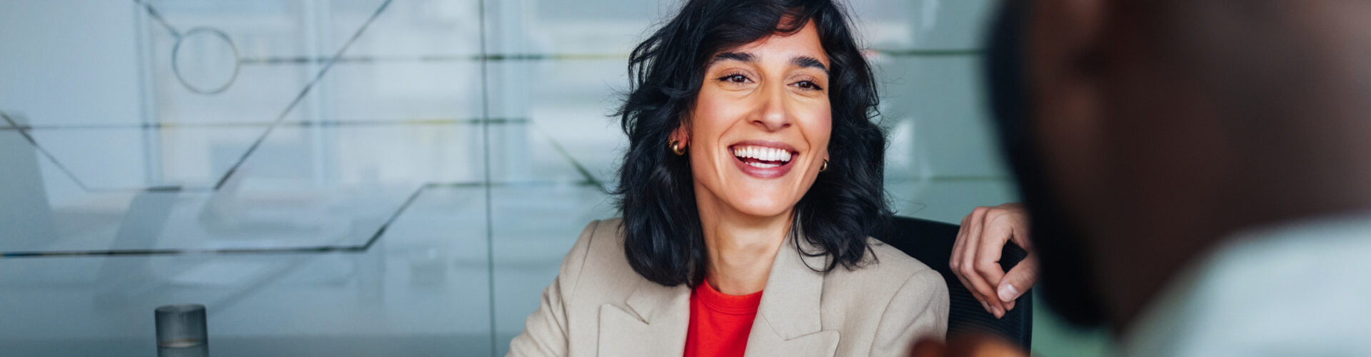 A business woman smiles at a colleague.