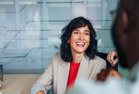 A business woman smiles at a colleague.