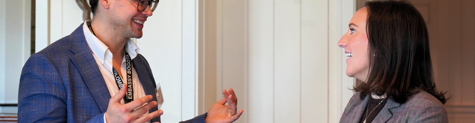 Two business people smile and converse with each other,