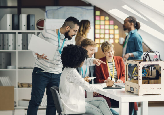 A tech worker speaks to a coworker in a shared office space.