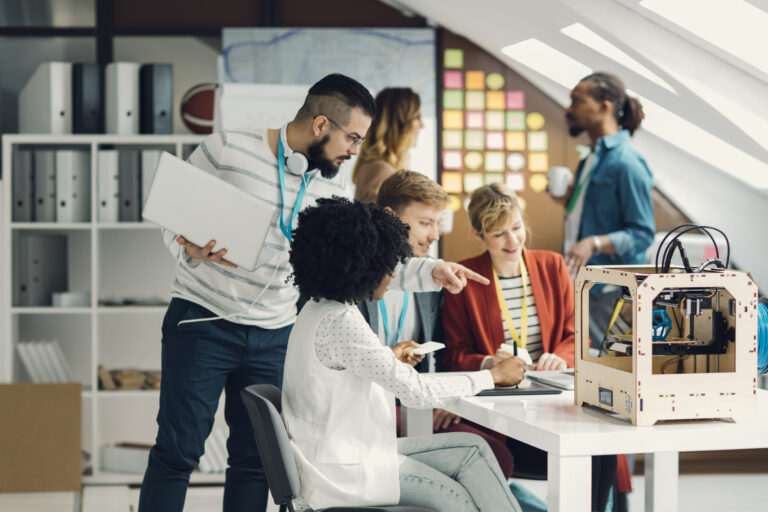 A tech worker speaks to a coworker in a shared office space.