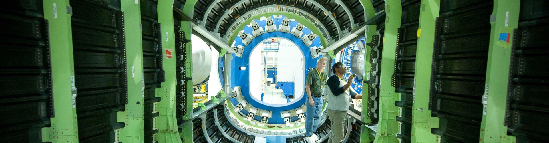 Two men work on the interior of an aerospace vehicle.