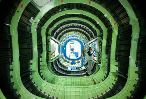 Two men work on the interior of an aerospace vehicle.
