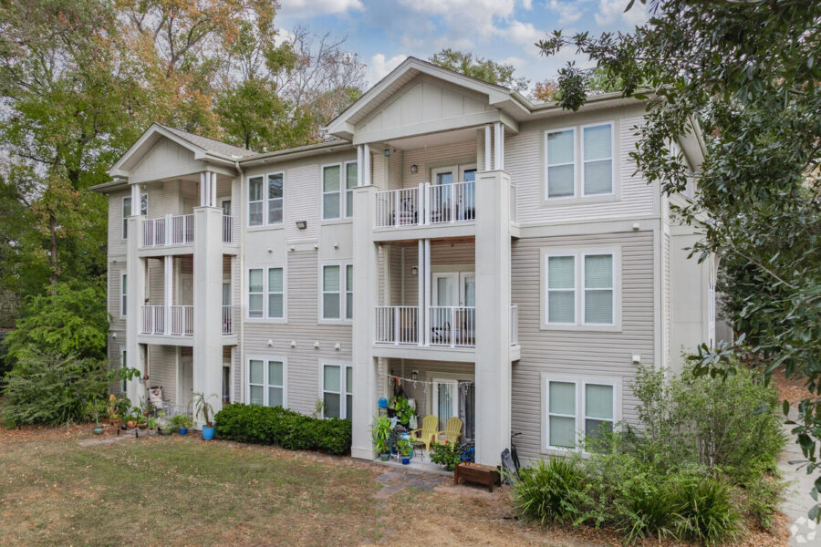 The exterior of a three-story apartment building with balconies.