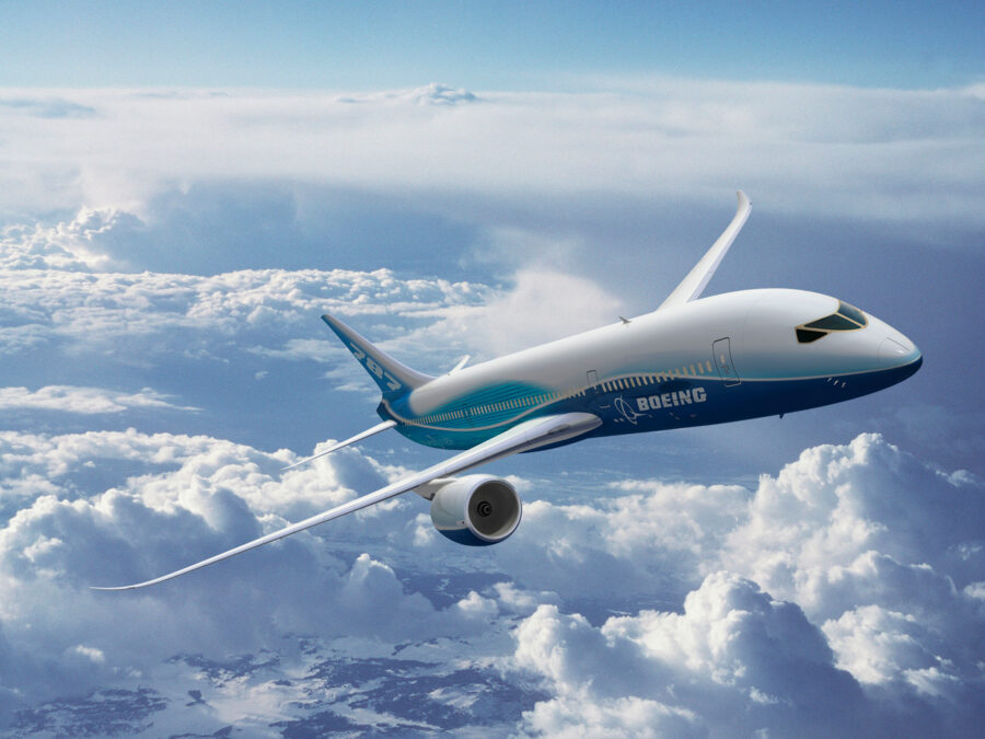 A Boeing 787 Dreamer aircraft in flight above the clouds.