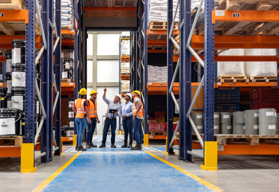 A group of people in construction gear stand in a manufacturing facility